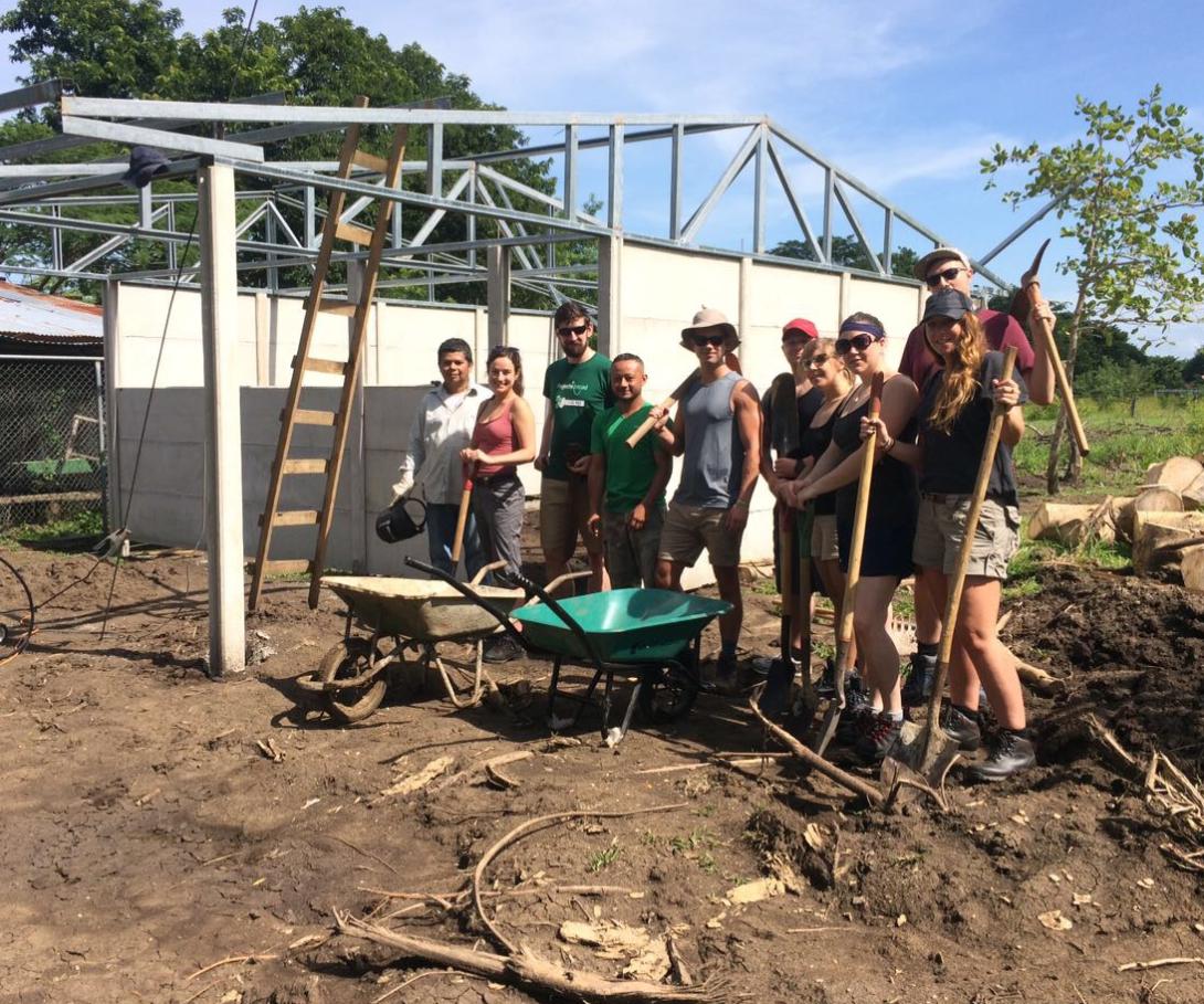 A group of corporate volunteers on a tailor-made trip take a break during building activities in Costa Rica. A corporate group on a bespoke volunteer trip at their building site in Costa Rica.